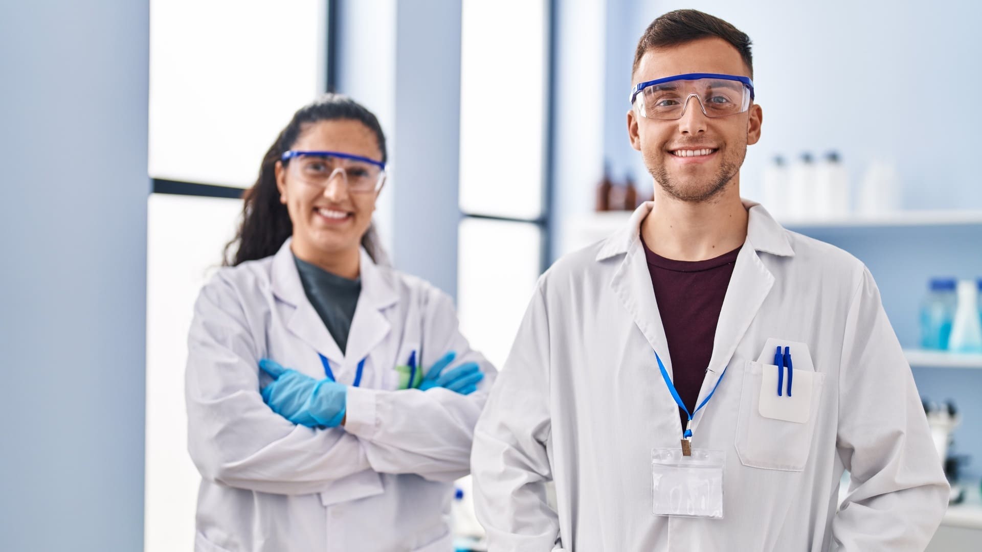 Man woman wearing scientist uniform standing with arms crossed gesture laboratory (1) (1) (1)
